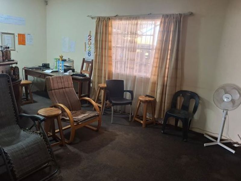 A living area featuring a window with curtains and carpeted flooring, suitable for renovation or restyling to modernize the space.