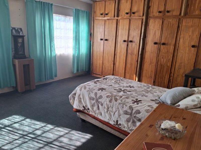 A bedroom featuring extensive built-in wooden cabinetry and carpeted flooring, offering ample storage space.