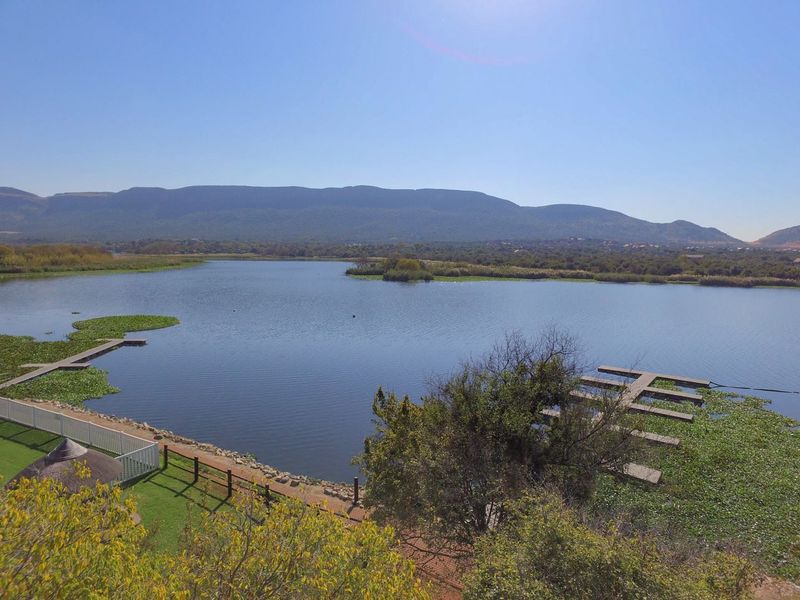 Scenic elevated view overlooking a tranquil lake with private jetties and surrounding natural landscape.