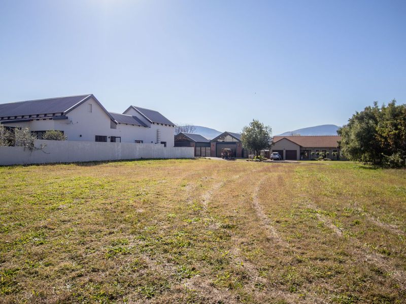 A vacant residential plot of land featuring established boundary walls and a clear view of the surrounding neighbourhood properties.