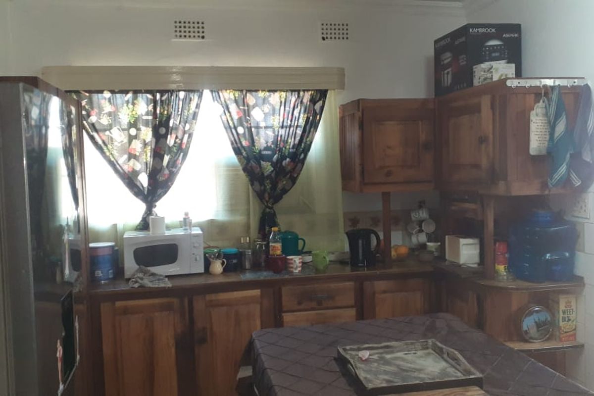A dated kitchen featuring traditional timber cabinetry, tiled splashbacks, and a functional layout with ample counter space.
