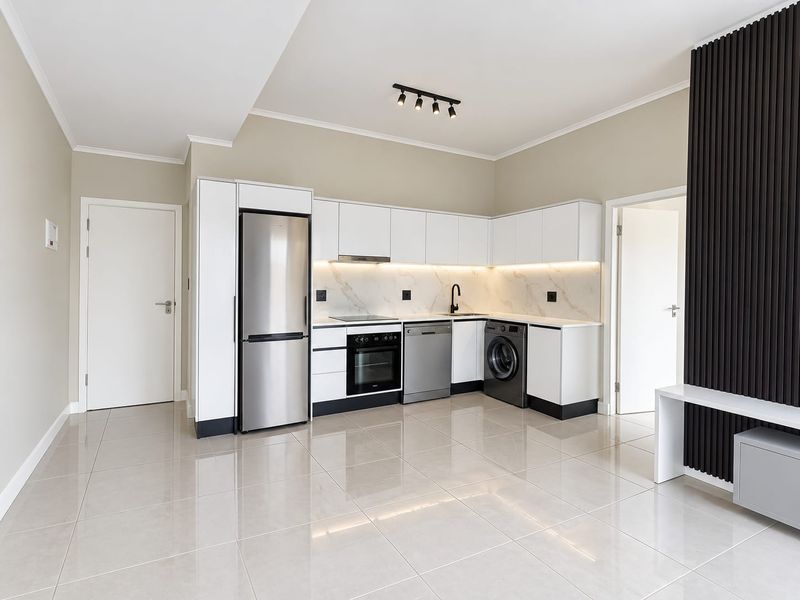 Modern, well-appointed kitchen featuring sleek white cabinetry, marble-look splashback, integrated appliances, and polished tile flooring in an open-plan layout.