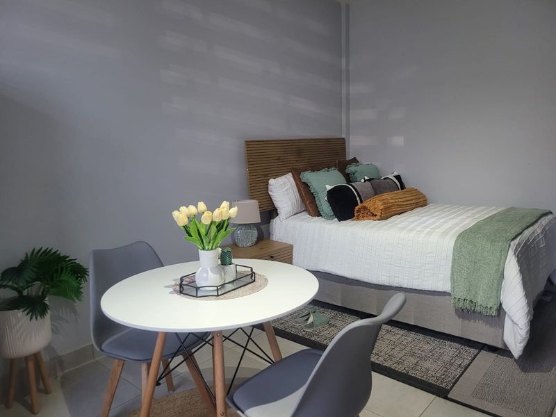 A well-maintained bedroom featuring neutral wall tones, tiled flooring, and a modern layout suitable for comfortable living.