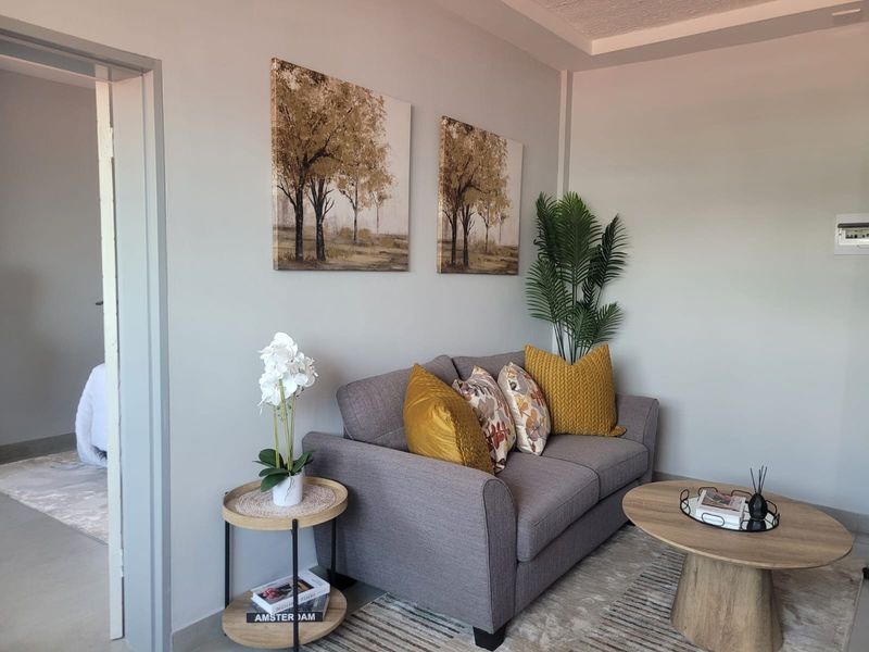 A well-maintained living room featuring neutral wall tones and a recessed ceiling detail, providing a comfortable and inviting space.