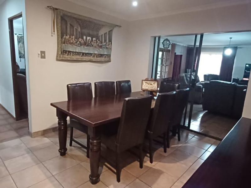 A dining area featuring tiled flooring and sliding glass doors that provide a view into the adjacent living room.