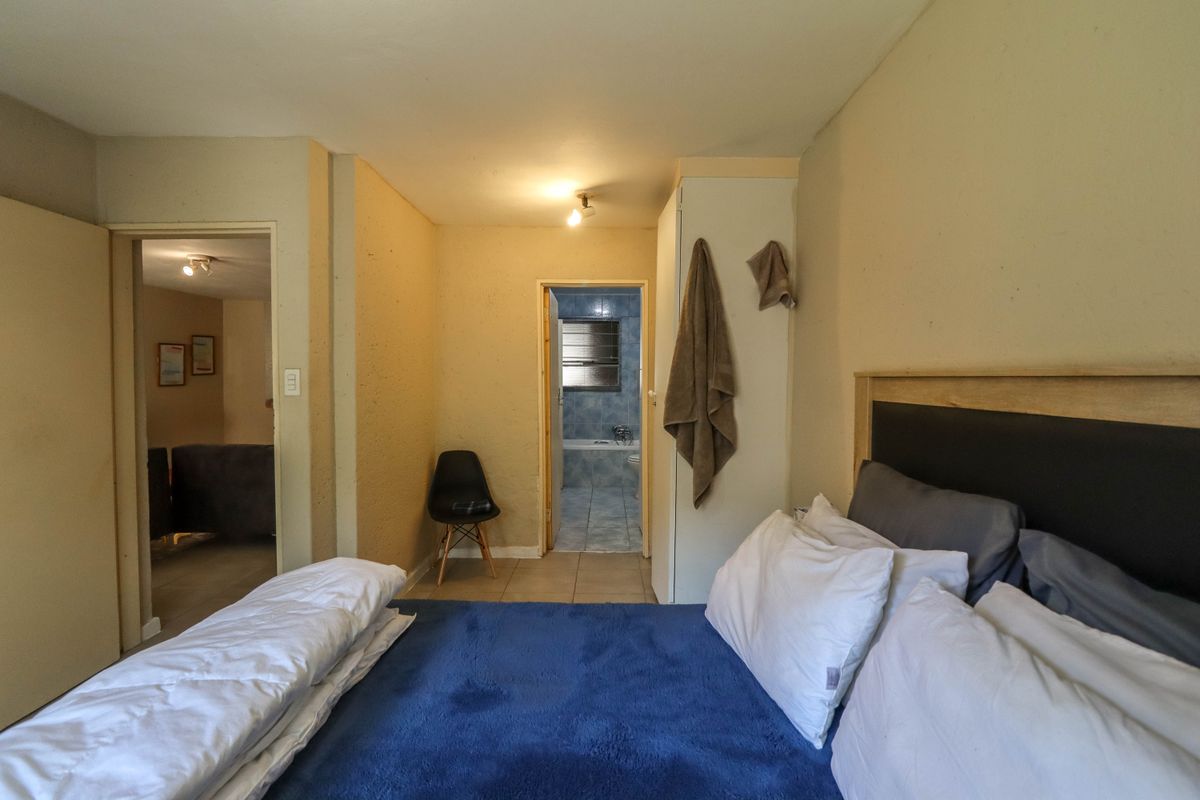 A bedroom featuring a built-in wardrobe and direct access to an en-suite bathroom with tiled flooring.
