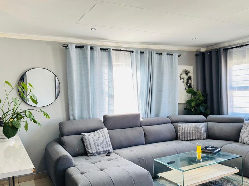 A comfortable living room featuring tiled flooring and recessed downlights, creating a bright and inviting space for relaxation.