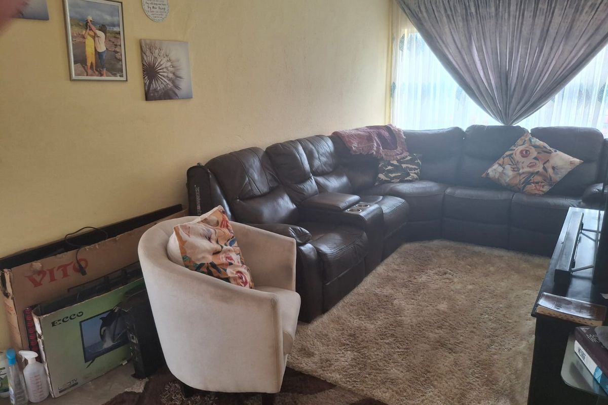 A living room area featuring a large window with curtains, providing a functional space for relaxation.