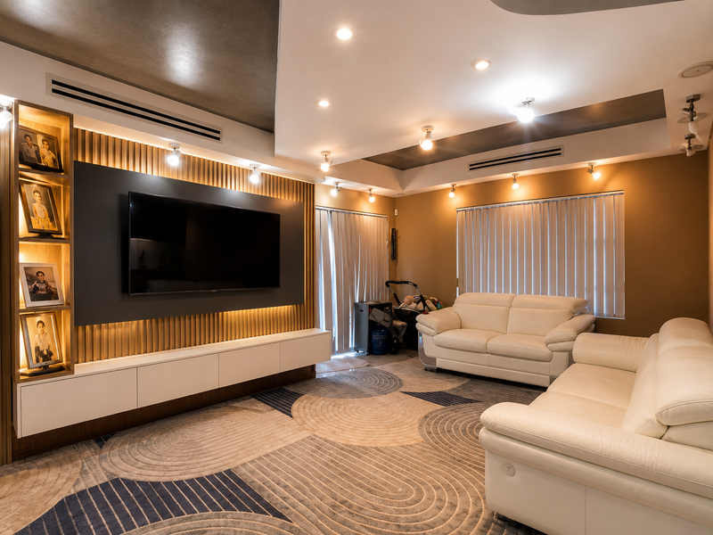 Modern living room featuring custom slatted timber wall paneling, integrated media console, recessed lighting, and ducted air conditioning.