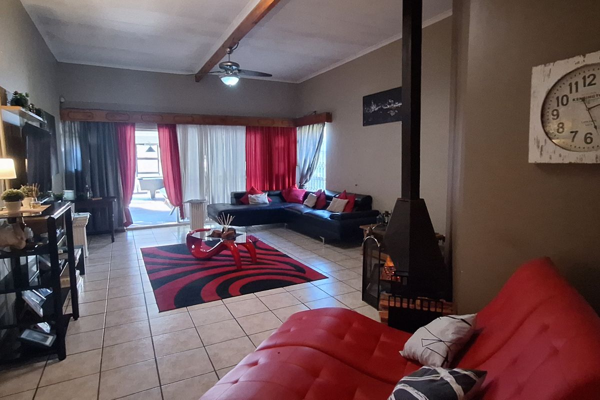 Spacious living room featuring tiled flooring, a built-in fireplace, and sliding glass doors providing access to the outdoor patio area.