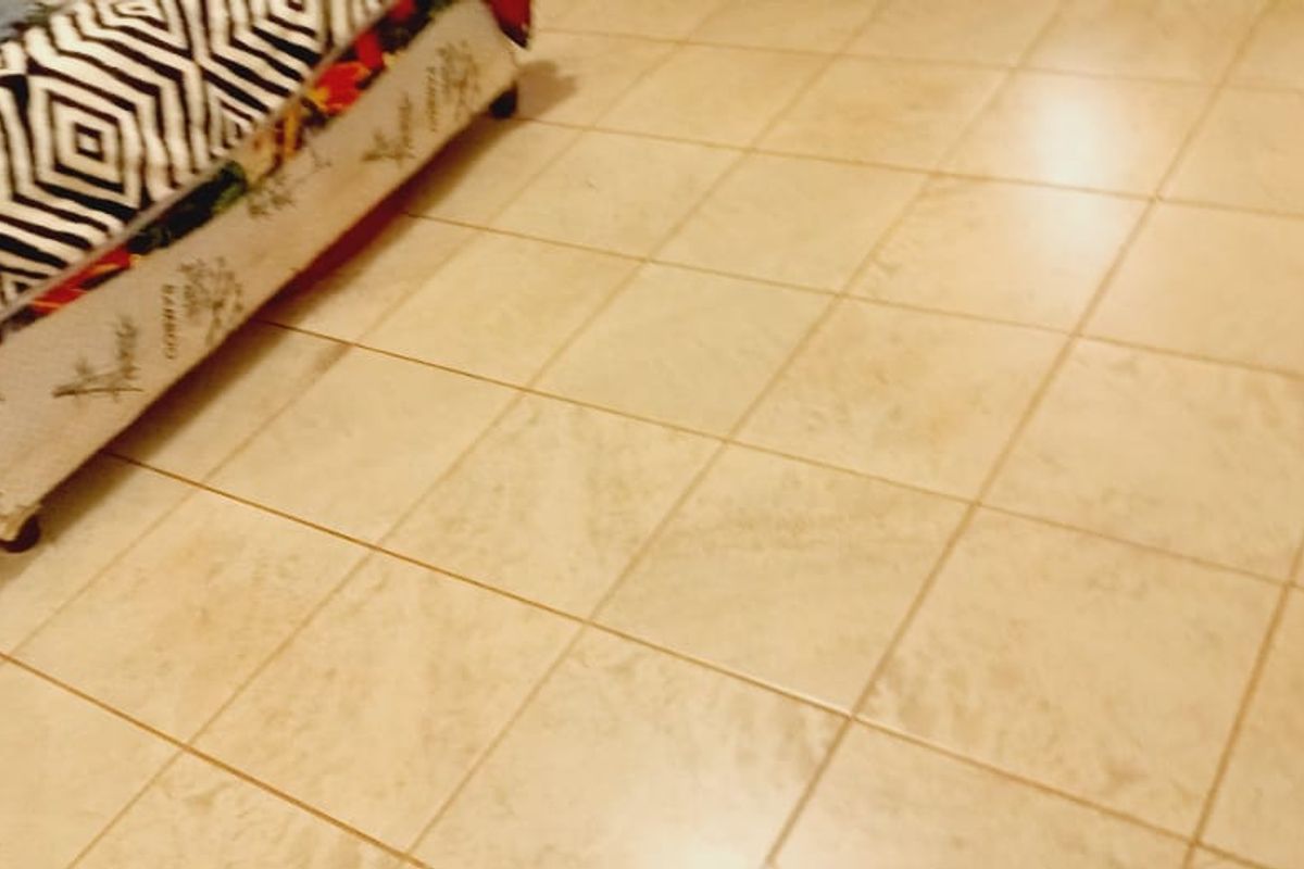 A bedroom interior featuring neutral ceramic floor tiling.