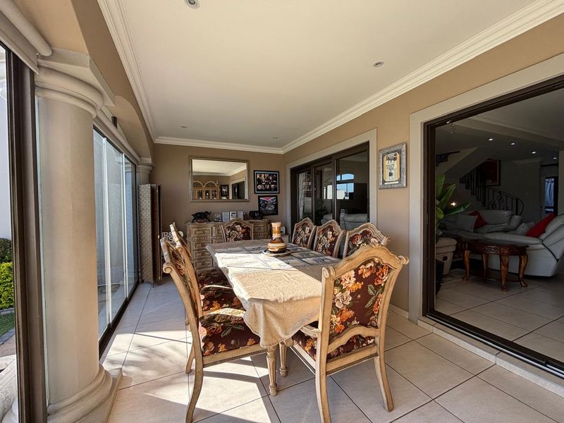 A covered patio area featuring tiled flooring, recessed lighting, and large sliding glass doors that provide seamless access to the interior living space.