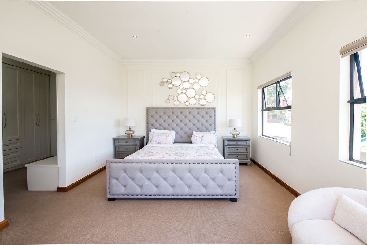 A well-maintained bedroom featuring crown molding, recessed lighting, casement windows, and a dedicated walk-in closet area with built-in cabinetry.