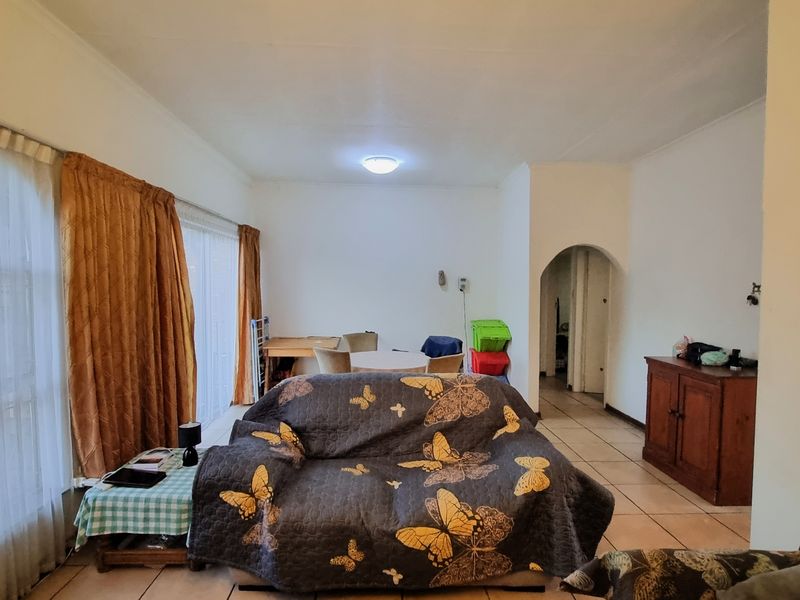 A spacious living area featuring tiled flooring and a classic archway leading to the rest of the home.
