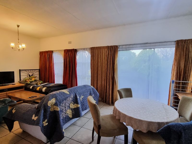 Open plan living and dining area featuring tiled flooring and large sliding glass doors that provide natural light.