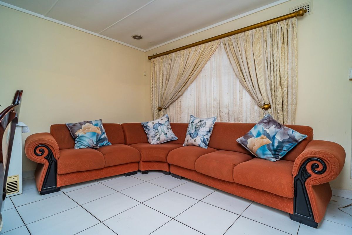 A living room featuring tiled flooring and recessed ceiling lighting, providing a functional space for relaxation.