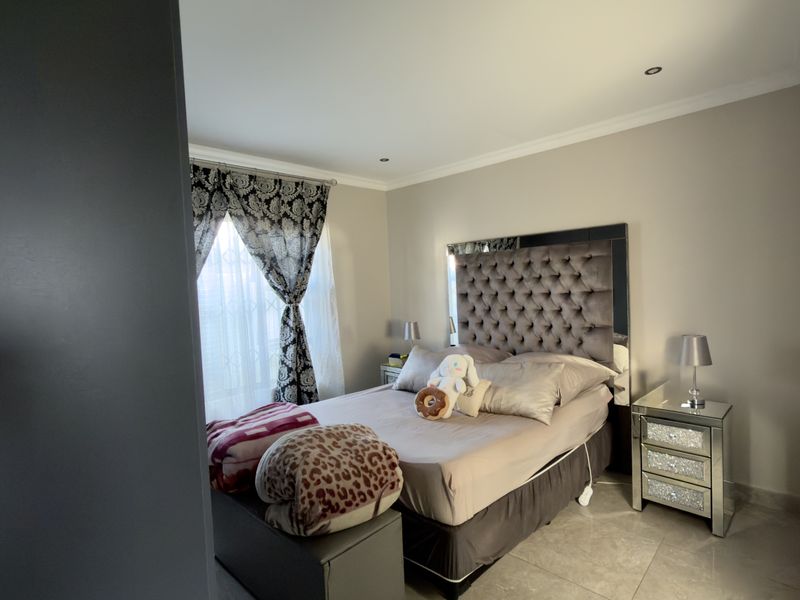 A well-maintained bedroom featuring tiled flooring, recessed downlighting, and coved cornicing, offering a clean and comfortable living space.