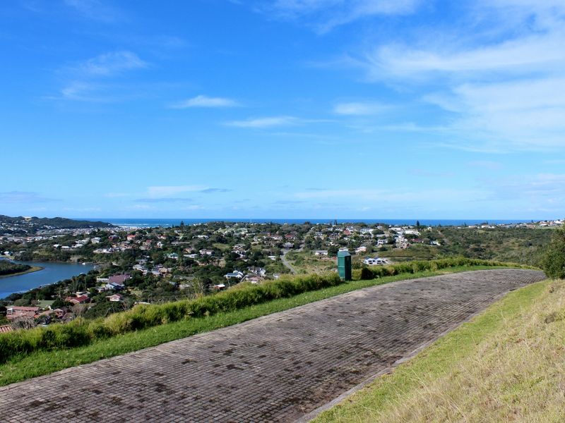 Elevated view overlooking the surrounding residential area, river, and distant coastline, featuring a paved driveway in the foreground.