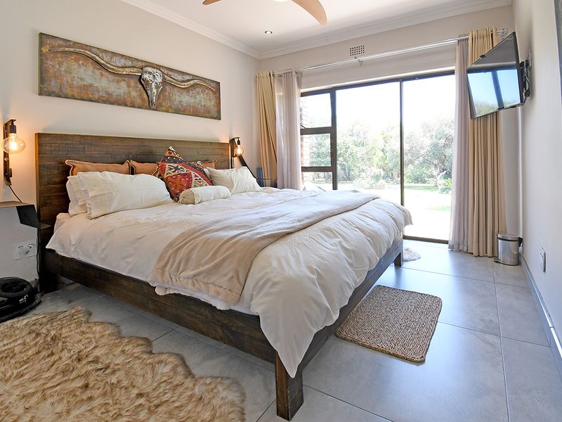 A well-maintained bedroom featuring large sliding glass doors that provide natural light and direct access to the garden area.