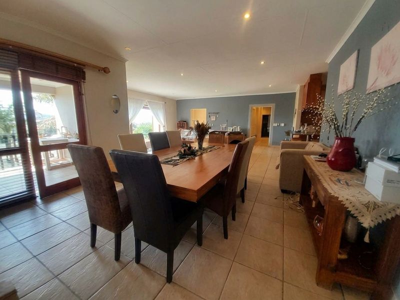 Spacious open-plan dining and living area featuring tiled flooring, recessed lighting, and direct access to an outdoor patio through sliding glass doors.