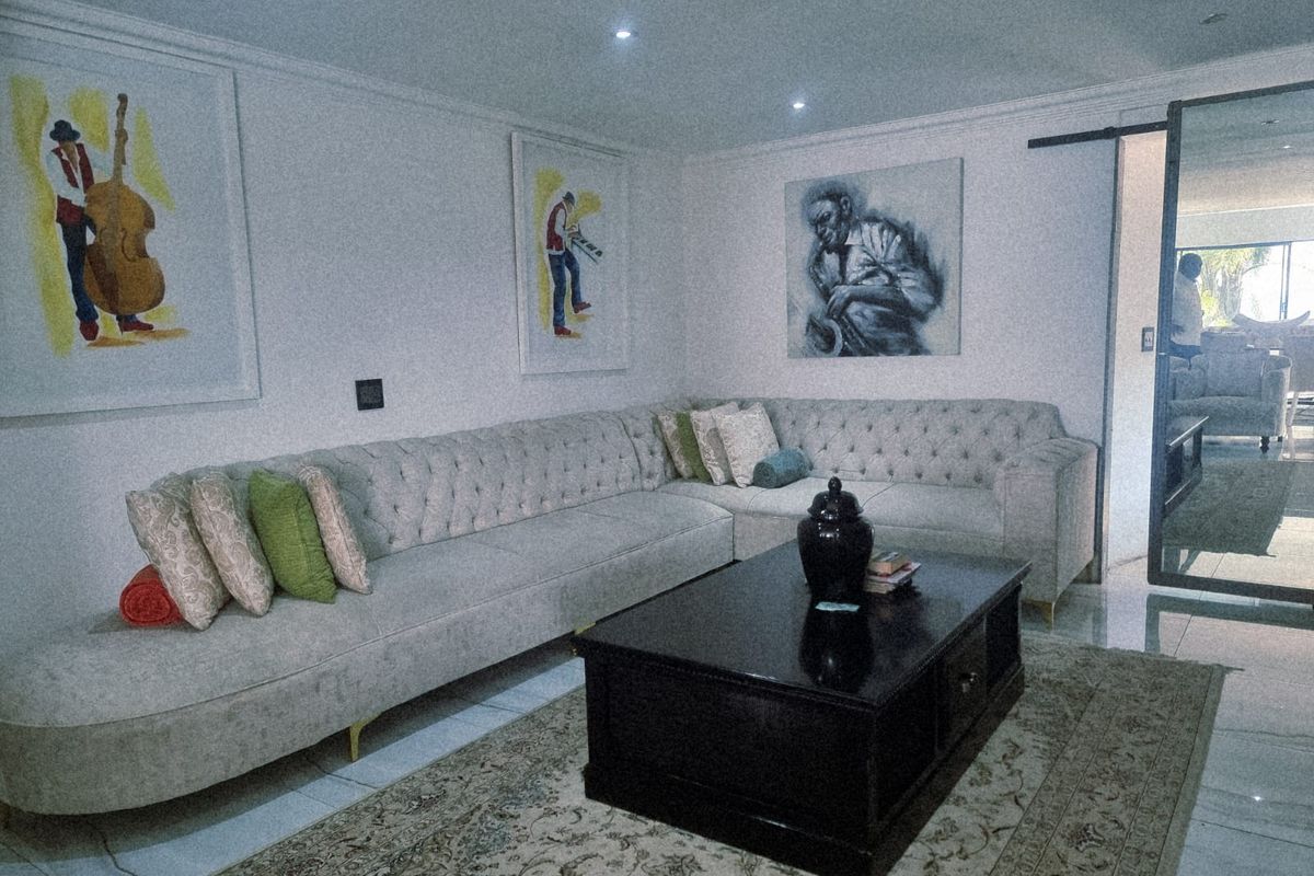 A well-maintained living room featuring recessed lighting, tiled floors, and a sliding barn door, creating a comfortable and modern living space.