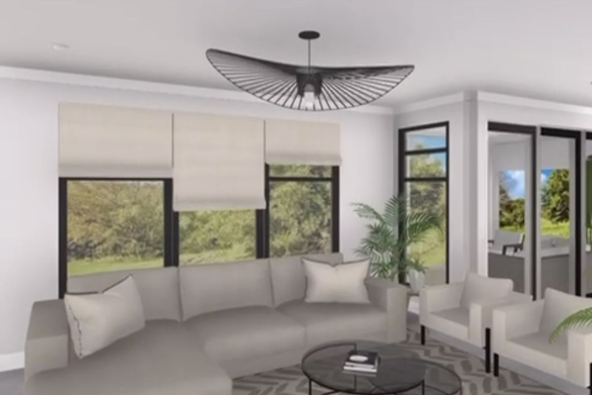 A bright, modern living room featuring large windows, sliding glass doors, and recessed lighting, creating an open and airy atmosphere.