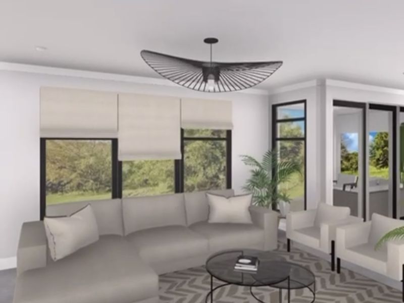 A bright, modern living room featuring large windows, sliding glass doors, and recessed lighting, creating an open and airy atmosphere.