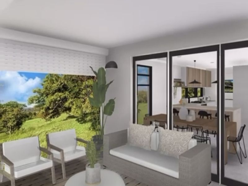 A covered patio area featuring large sliding glass doors that provide a seamless transition to the interior living and kitchen space.