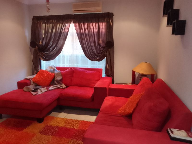 A living room featuring tiled flooring and a wall-mounted split-system air conditioning unit.