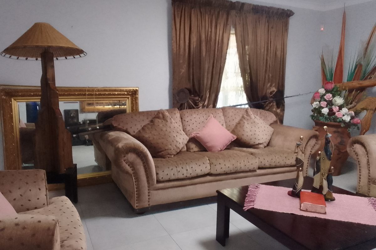 A living room featuring tiled flooring and window treatments, providing a functional space for relaxation.
