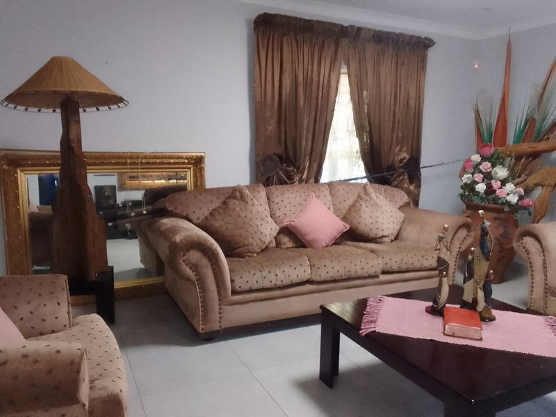 A living room featuring tiled flooring and window treatments, providing a functional space for relaxation.