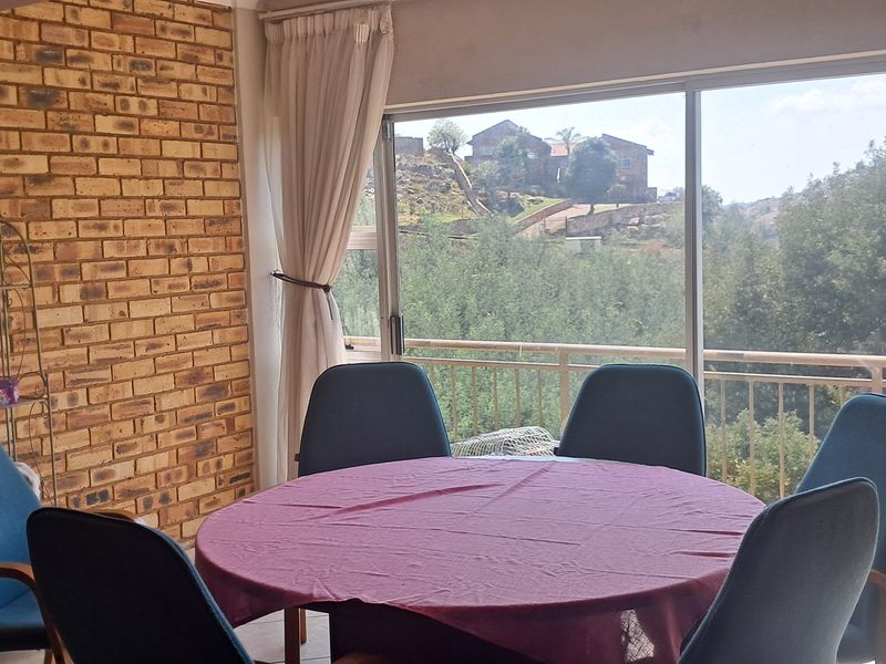 Dining area featuring an exposed brick wall and large sliding glass doors opening onto a balcony with scenic views.