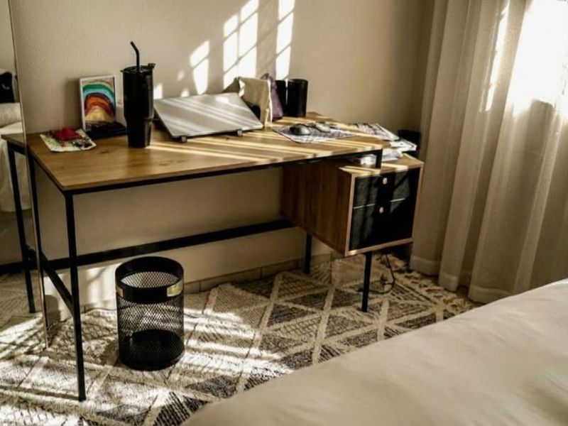 A bedroom interior featuring natural light through curtains, creating a warm and inviting atmosphere.