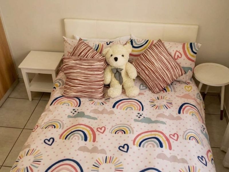 A compact bedroom featuring tiled flooring and a built-in wardrobe, providing functional storage space.