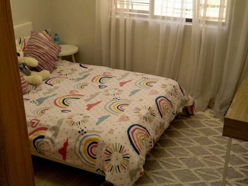 A cozy bedroom featuring a window with sheer curtains and neutral flooring, providing a comfortable and functional living space.