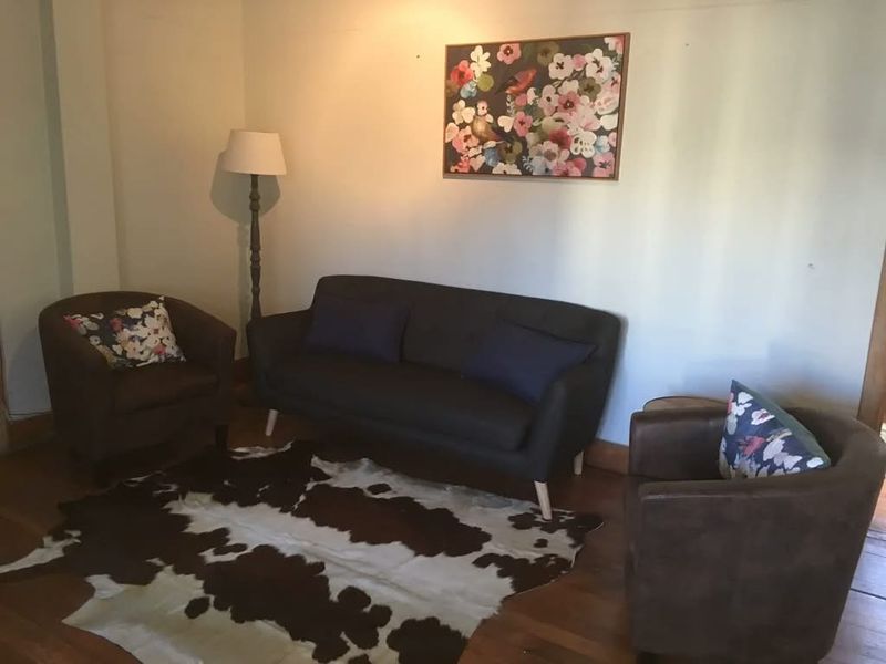 A cozy living room area featuring warm hardwood flooring and neutral wall finishes.