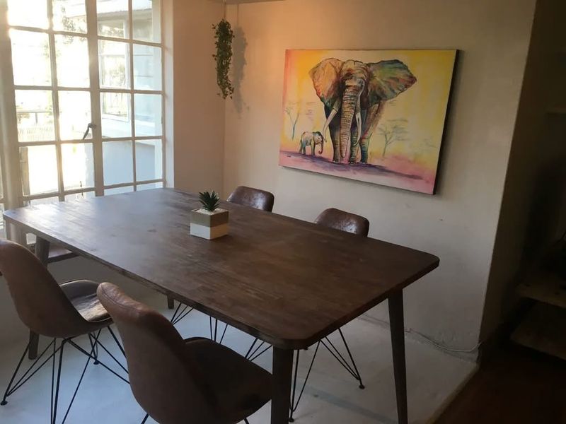 A dining area featuring a large multi-pane window that provides natural light, creating a bright and inviting space for meals.