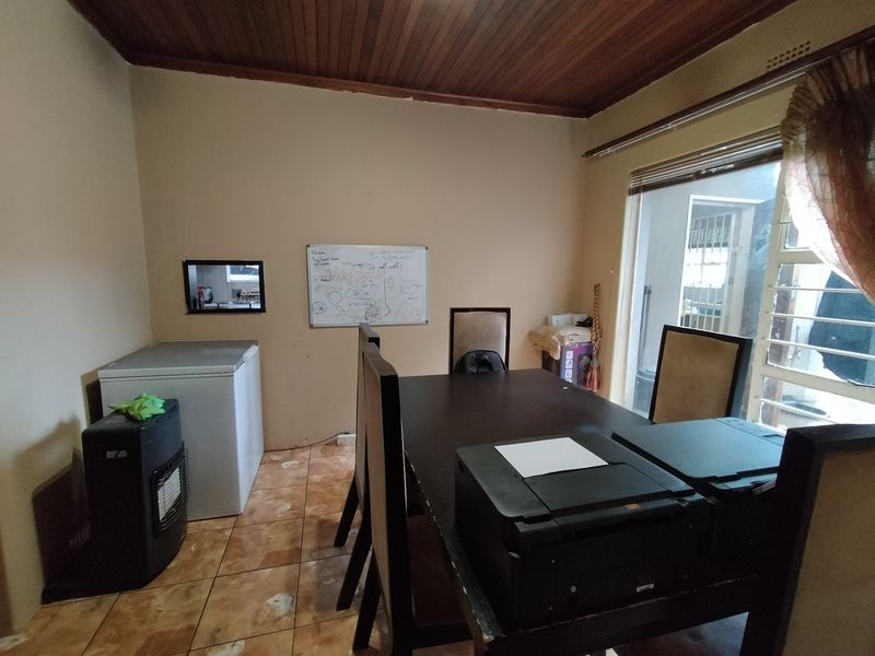 Dining room featuring a timber ceiling, ceramic tiled flooring, and a serving hatch connecting to the kitchen area.