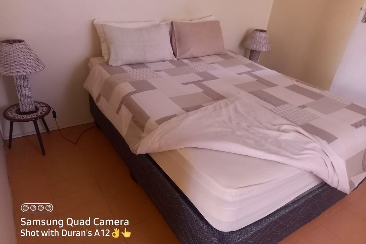 A simple bedroom featuring tiled flooring and neutral wall finishes.