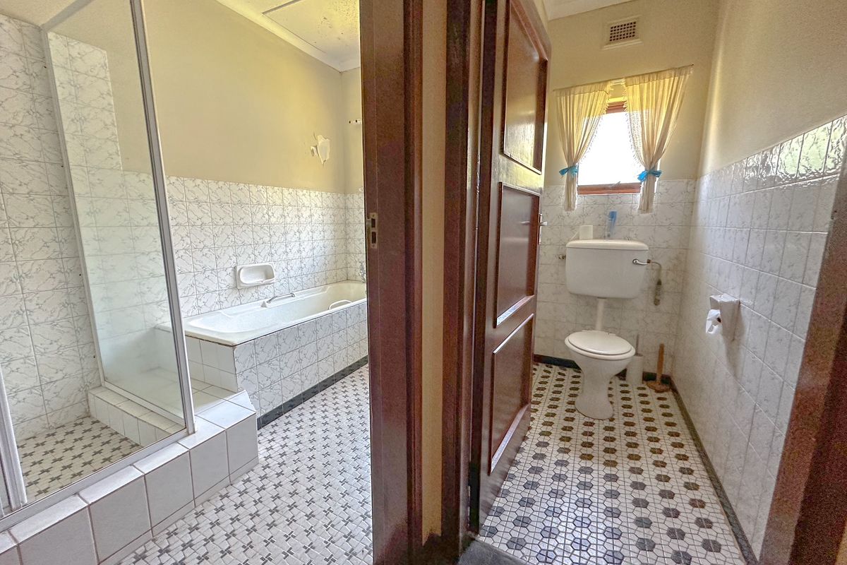 A dated bathroom featuring a separate shower enclosure, built-in bathtub, and toilet with classic ceramic tiling throughout.