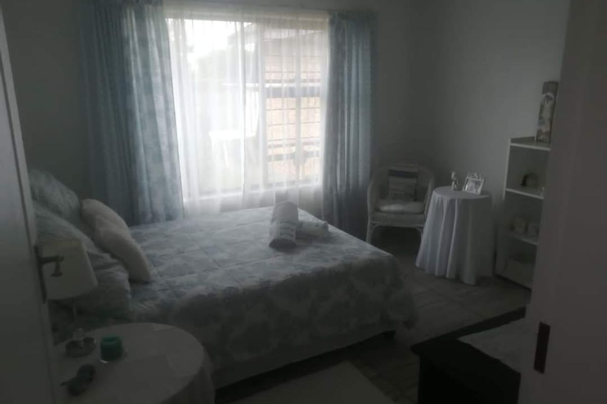 A standard bedroom featuring a window with curtains, providing natural light and a view of the exterior.