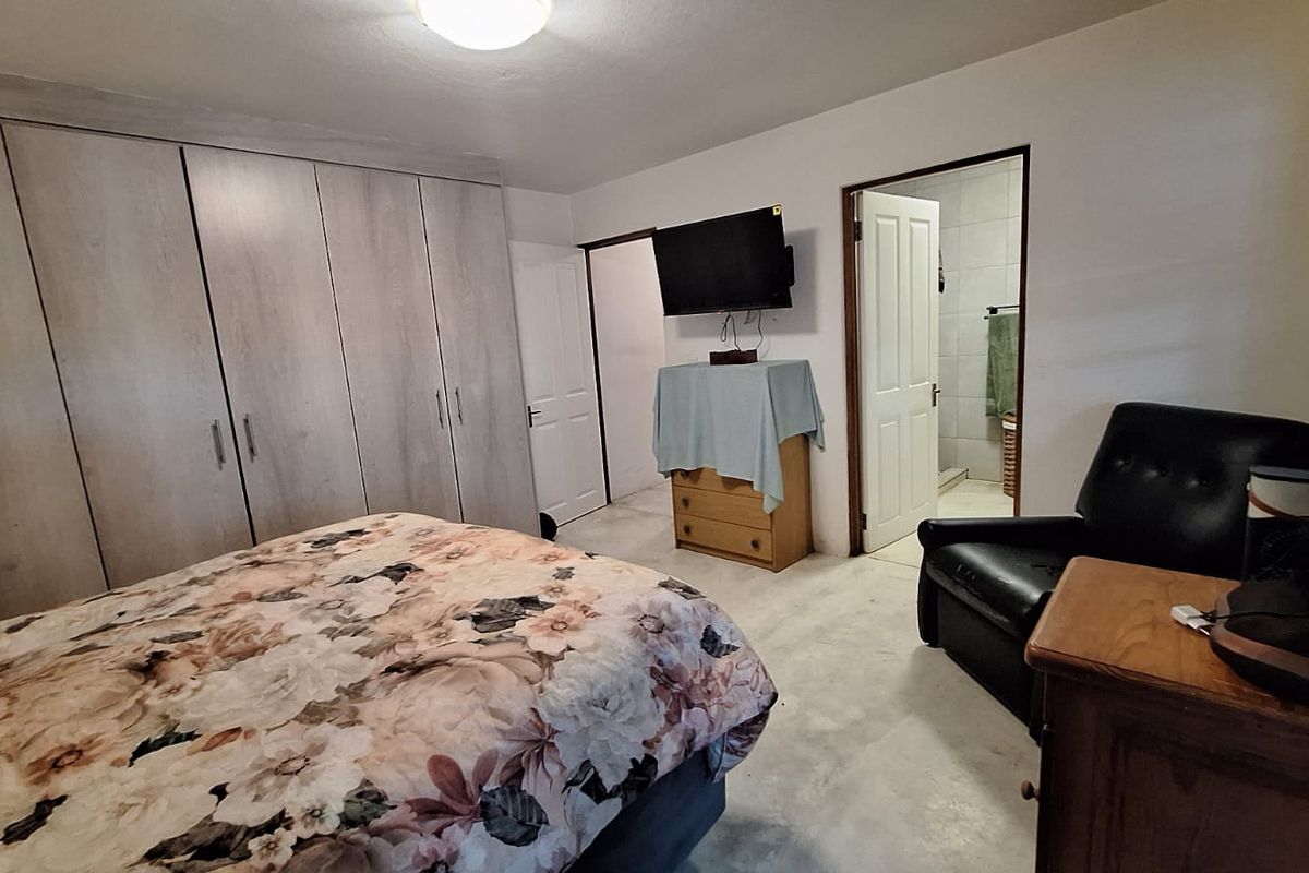 A bedroom featuring built-in cupboards and direct access to an en-suite bathroom.