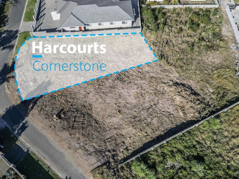 An aerial view of a vacant residential plot with boundary fencing, showing the cleared land ready for development.
