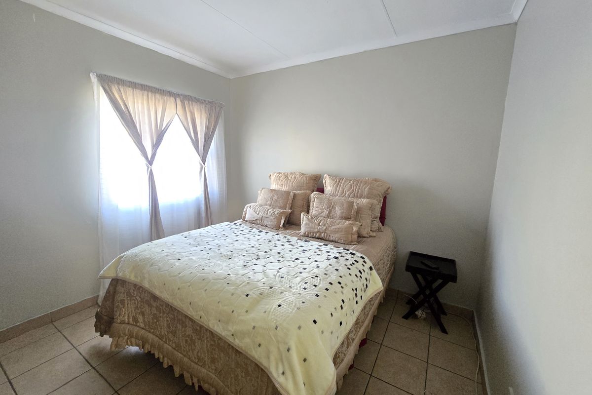 A standard bedroom featuring tiled flooring and a coved ceiling, providing a neutral foundation for personalization.