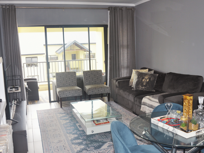 Open plan living area featuring tiled flooring and large sliding glass doors providing direct access to a private balcony.