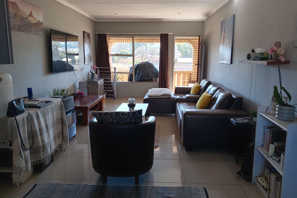 A comfortable living room featuring tiled flooring, recessed lighting, and direct access to an outdoor patio area through a sliding door.