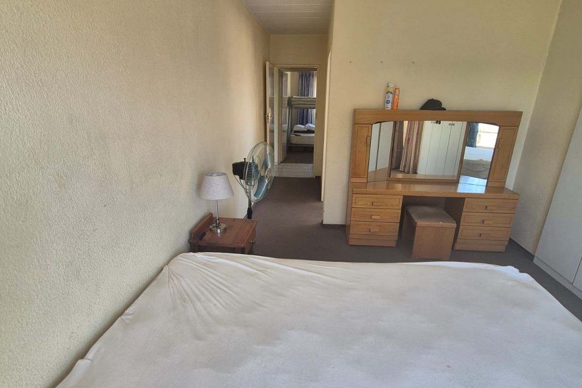 A bedroom featuring carpeted flooring and a textured ceiling, offering a functional space with potential for modernization.