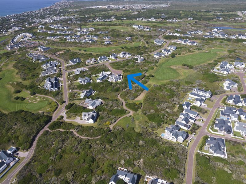 An aerial view of a residential estate situated within a golf course landscape, highlighting the property location and surrounding coastal environment.