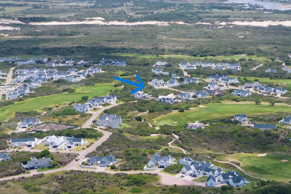 An aerial view of a residential estate situated within a coastal landscape and golf course setting, highlighting the property location.