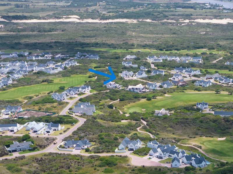 An aerial view of a residential estate situated within a coastal landscape and golf course setting, highlighting the property location.